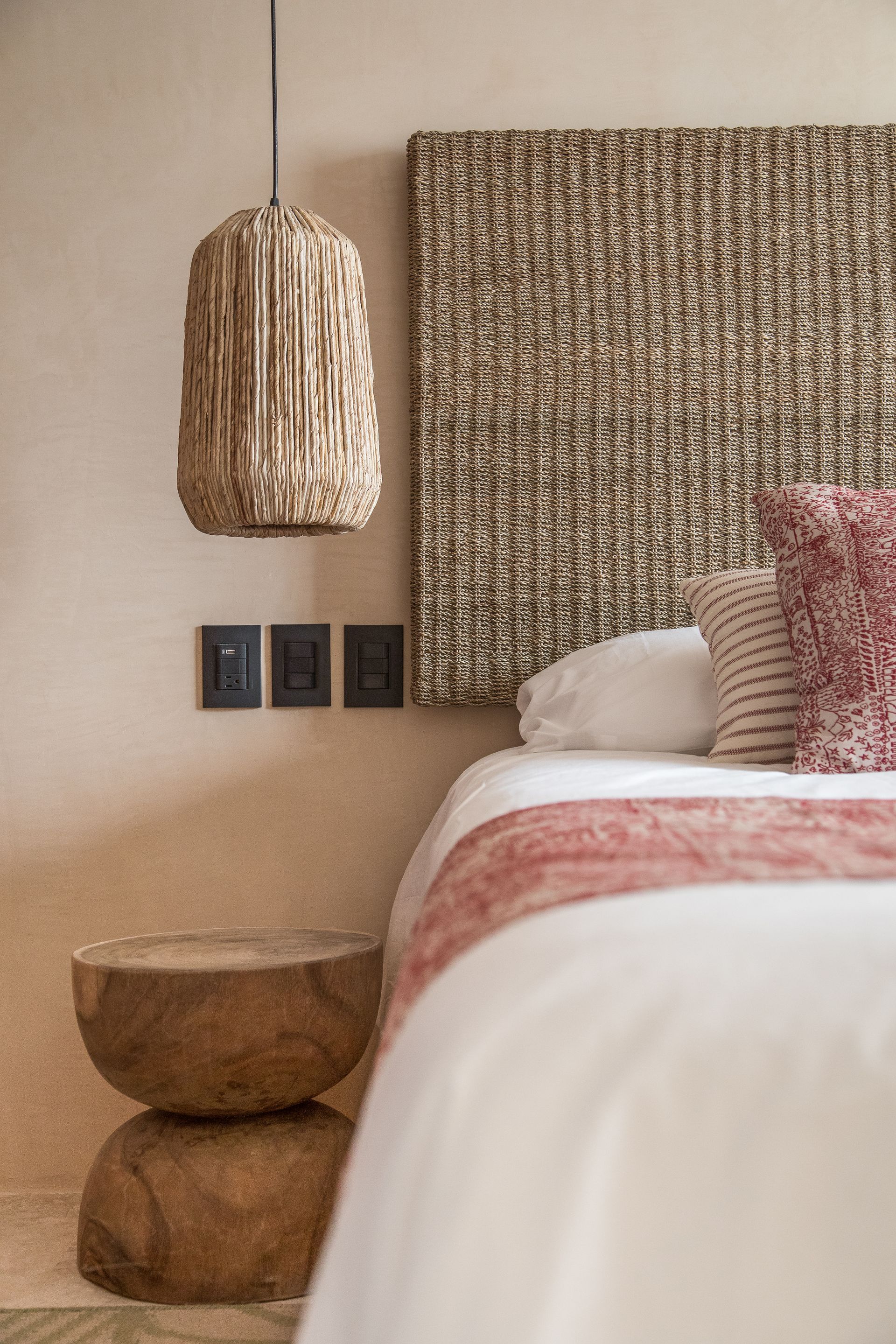 A bedroom with a bed , nightstand , lamp and painting on the wall.