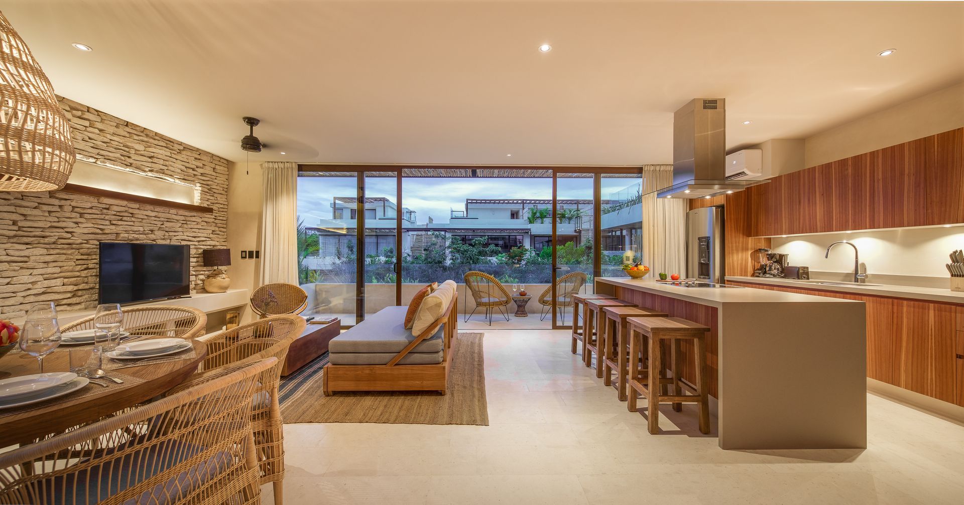 A living room with a couch , table , chairs and a kitchen.