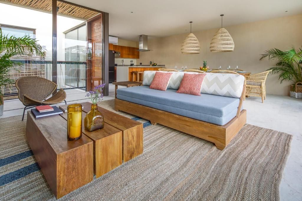 A living room with a couch , table , chairs and a rug.