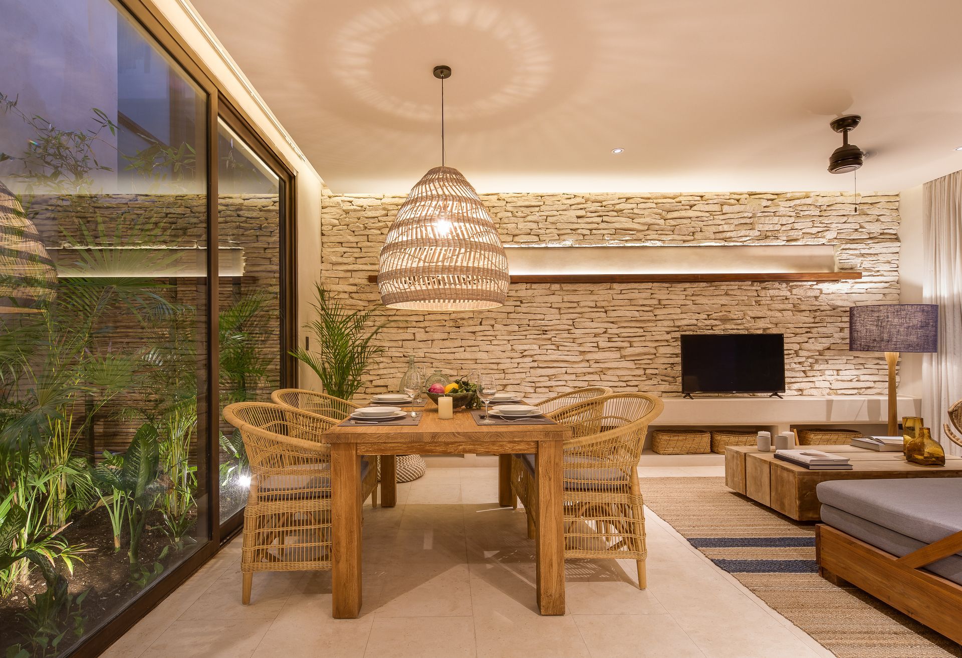 A dining room with a wooden table and chairs and a television.