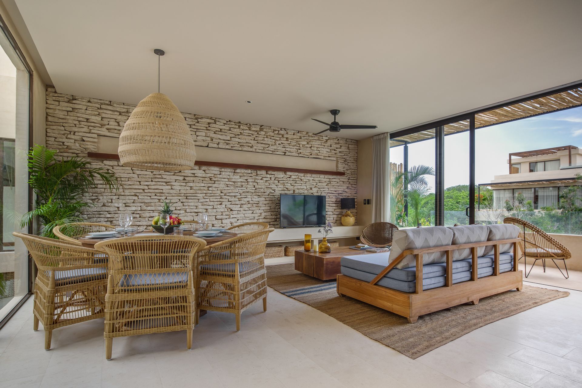 A living room with a couch , chairs , a table and a television.