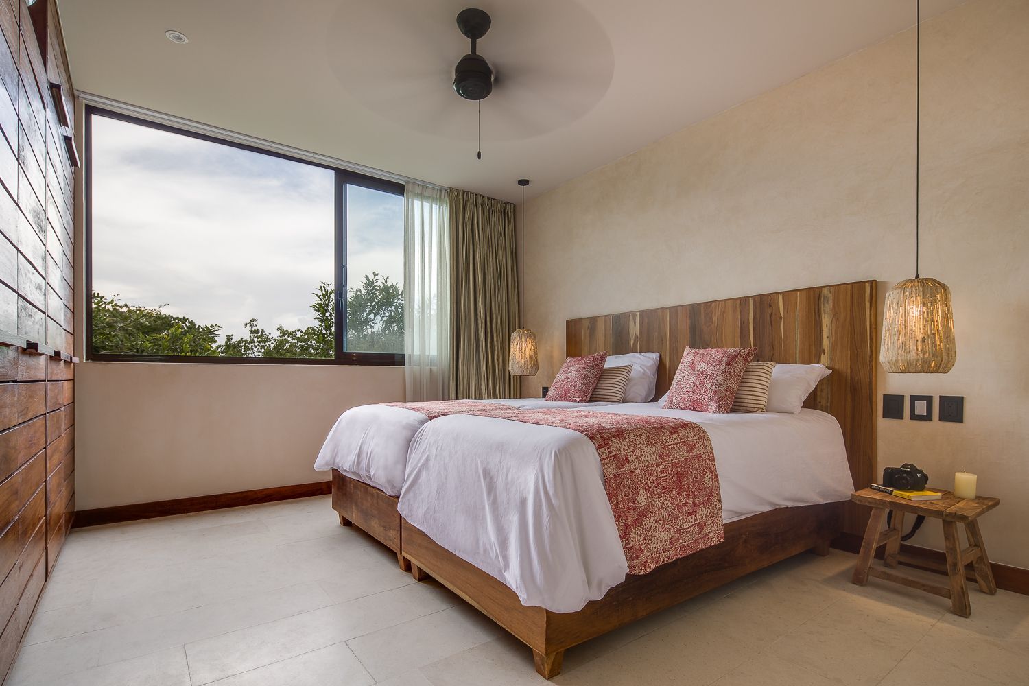 A bedroom with two beds and a ceiling fan.