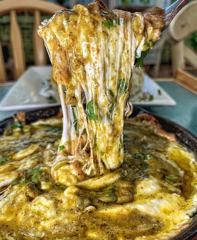 A close up of a pizza with cheese coming out of it.
