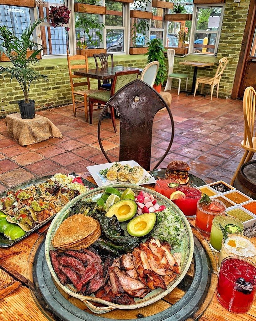 A table topped with plates of food and drinks in a restaurant.
