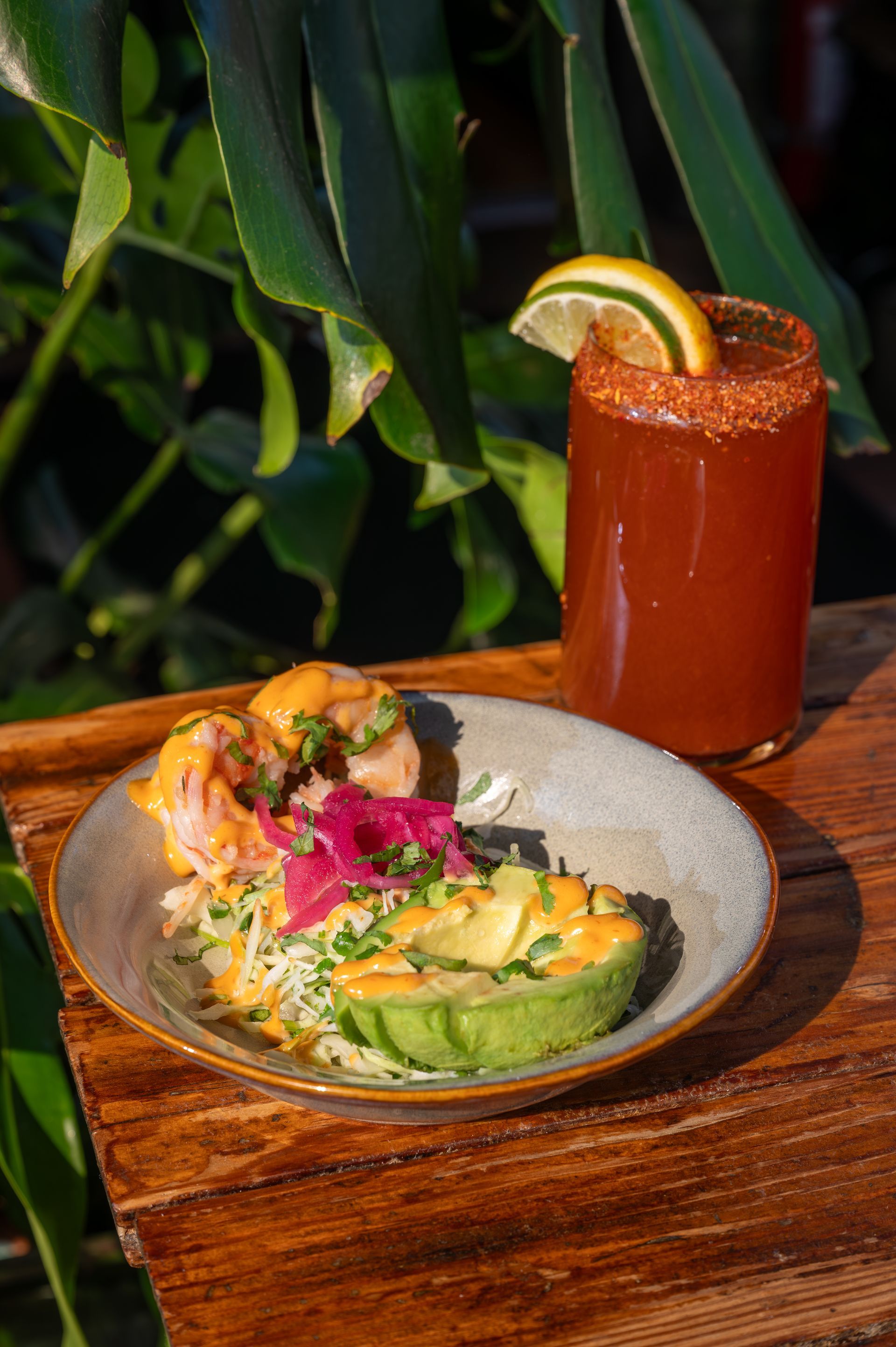 A plate of food and a drink on a wooden table.