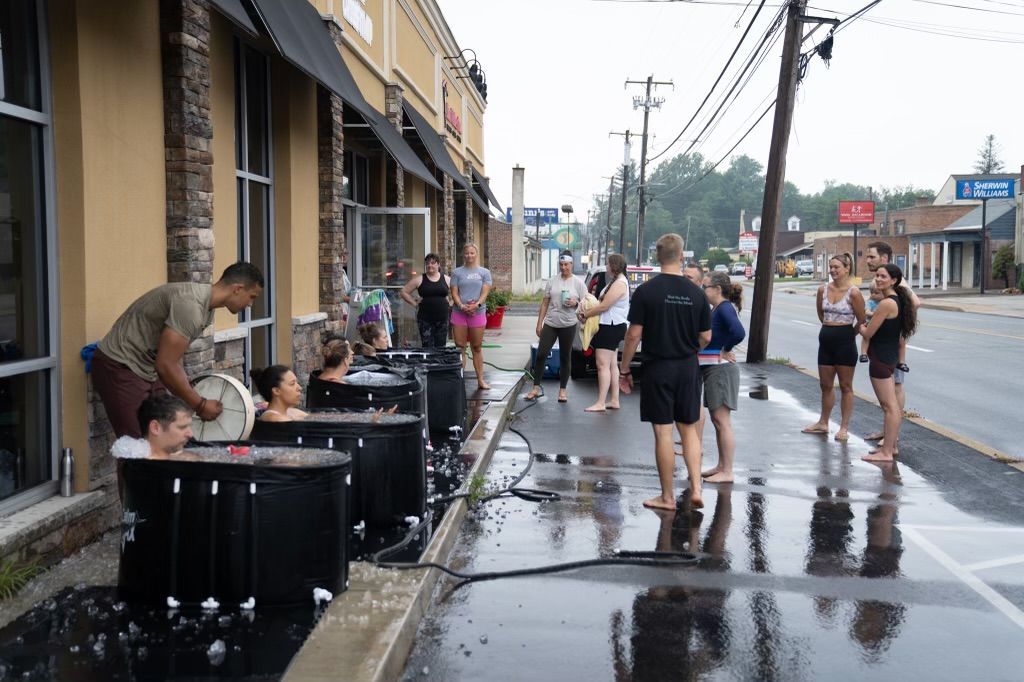 A group of people are standing in a pool of water on the side of the road.