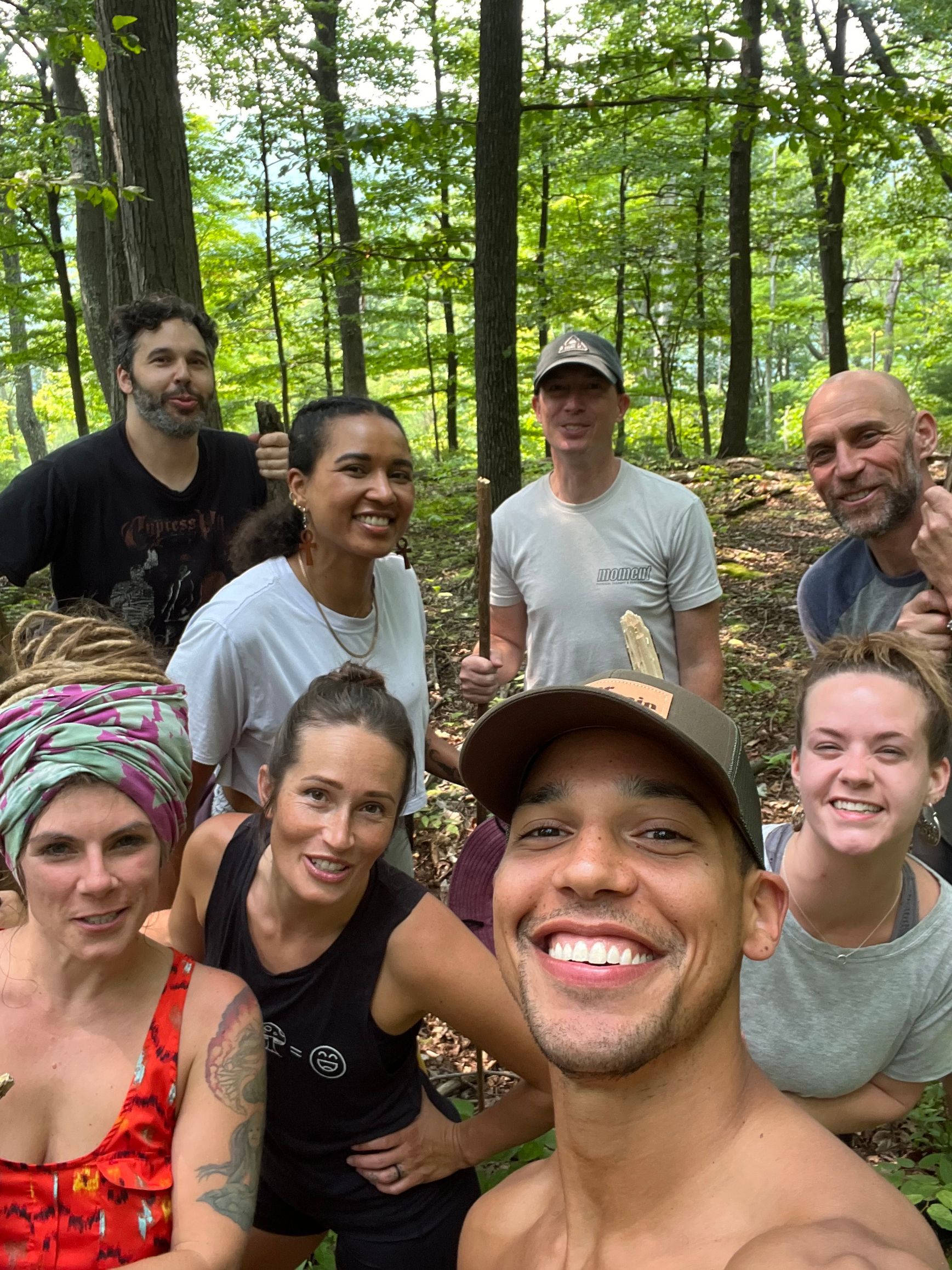 A group of people are posing for a picture in the woods.