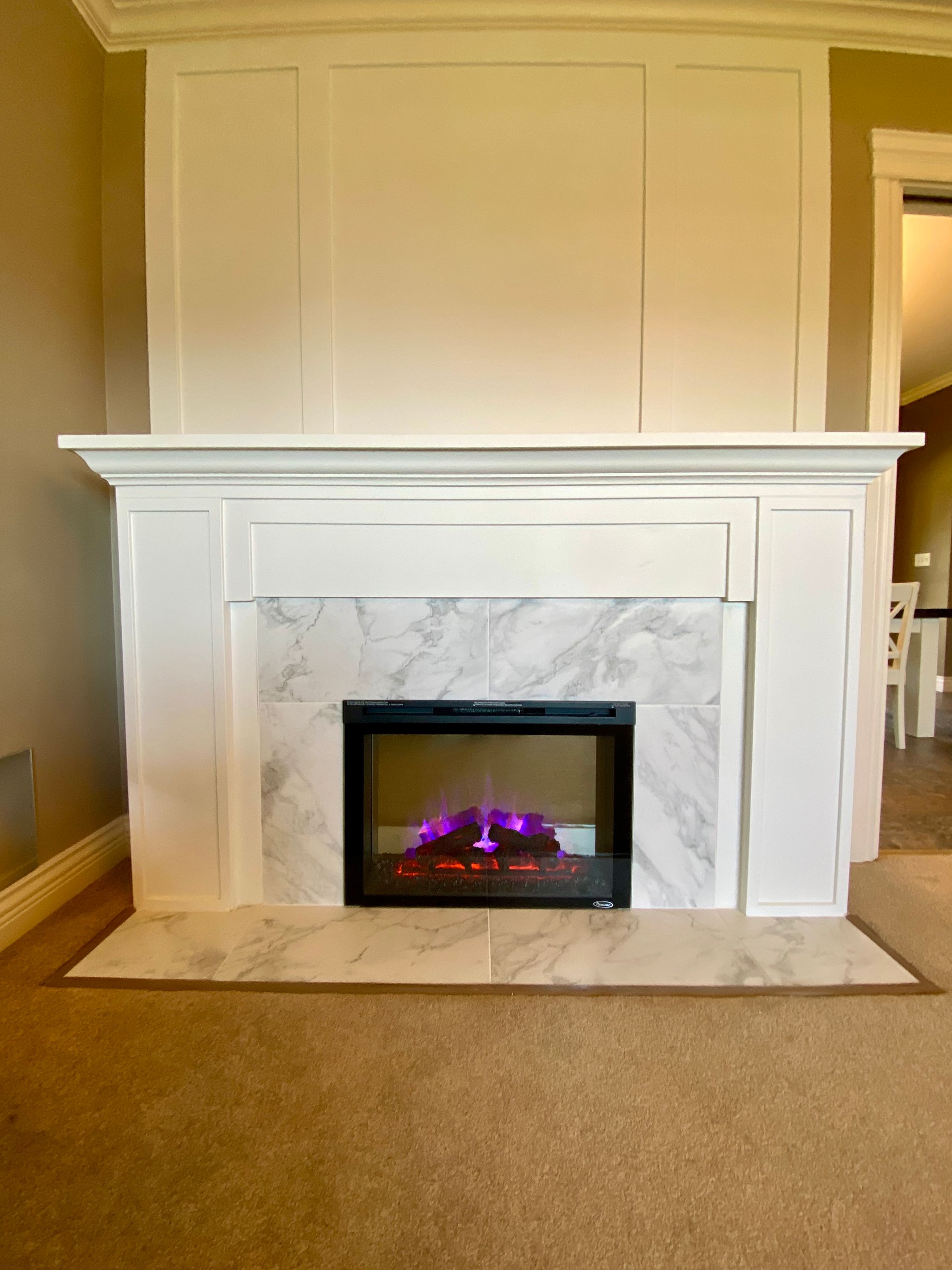 Custom Home Renovation - A fireplace with a purple flame is in a living room