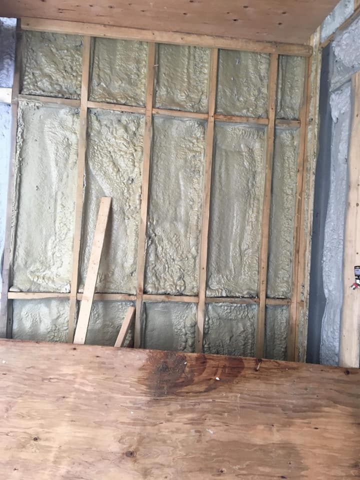 Mur en bois avec isolation en mousse pulvérisée entre les montants.