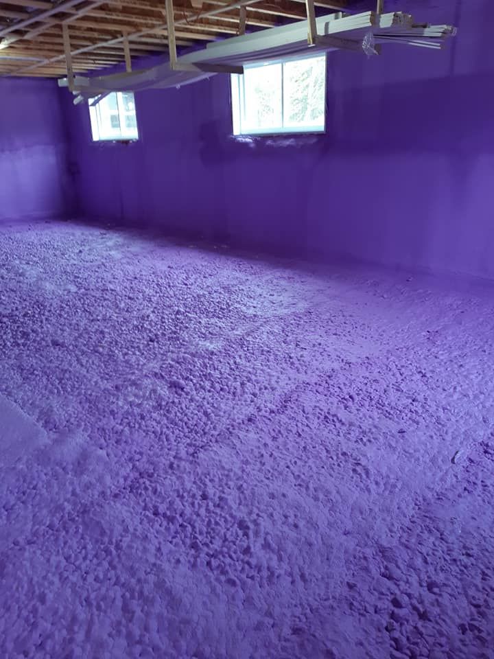 Chambre peinte en violet avec sol texturé, deux fenêtres et poutres apparentes au plafond.