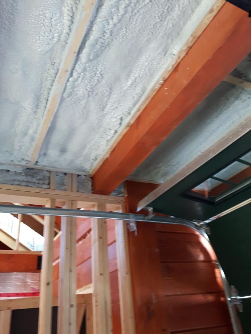 Plafond isolé avec mousse blanche, poutres orange, structures en bois.