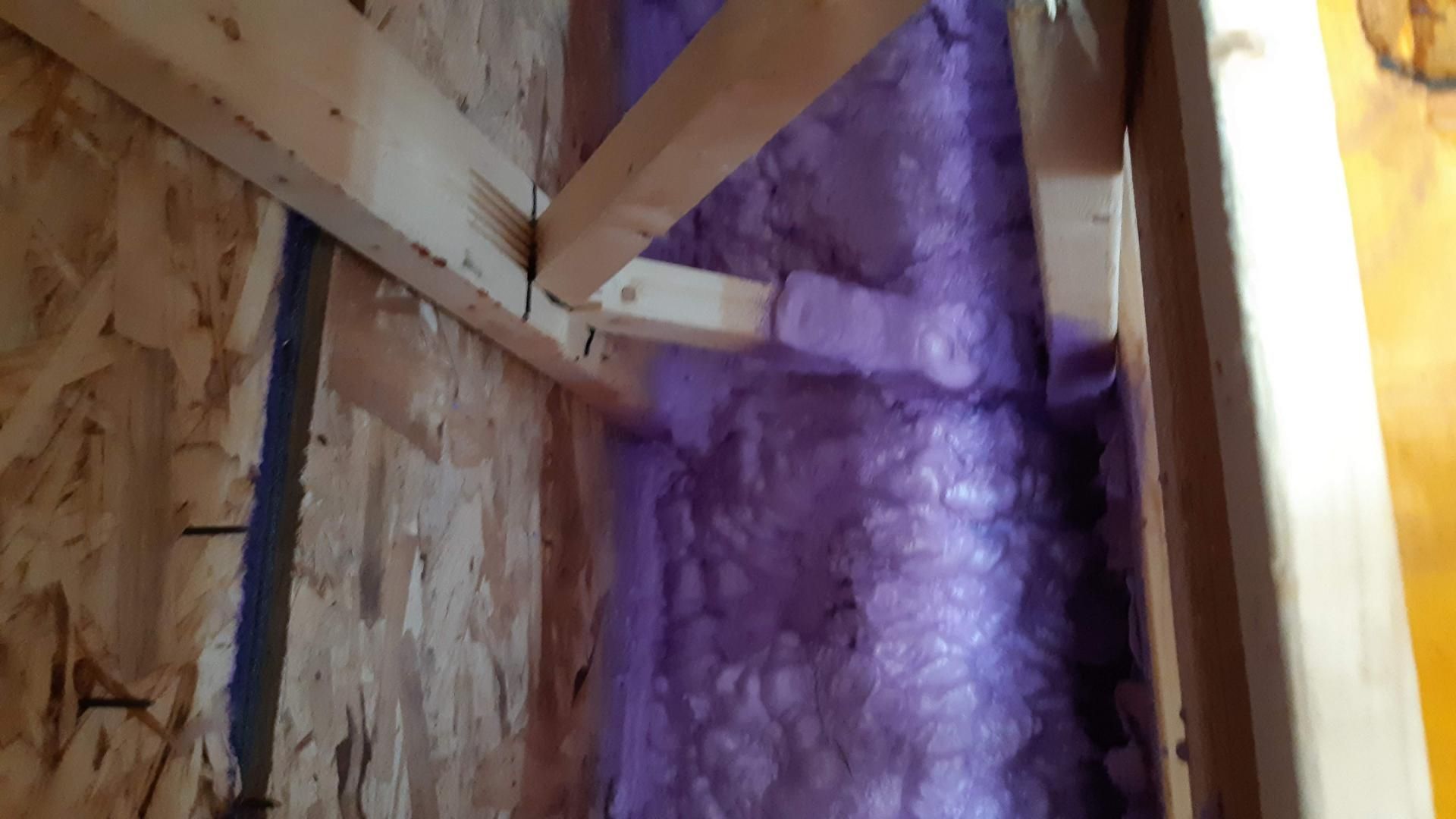 Charpente murale intérieure avec isolation violette.