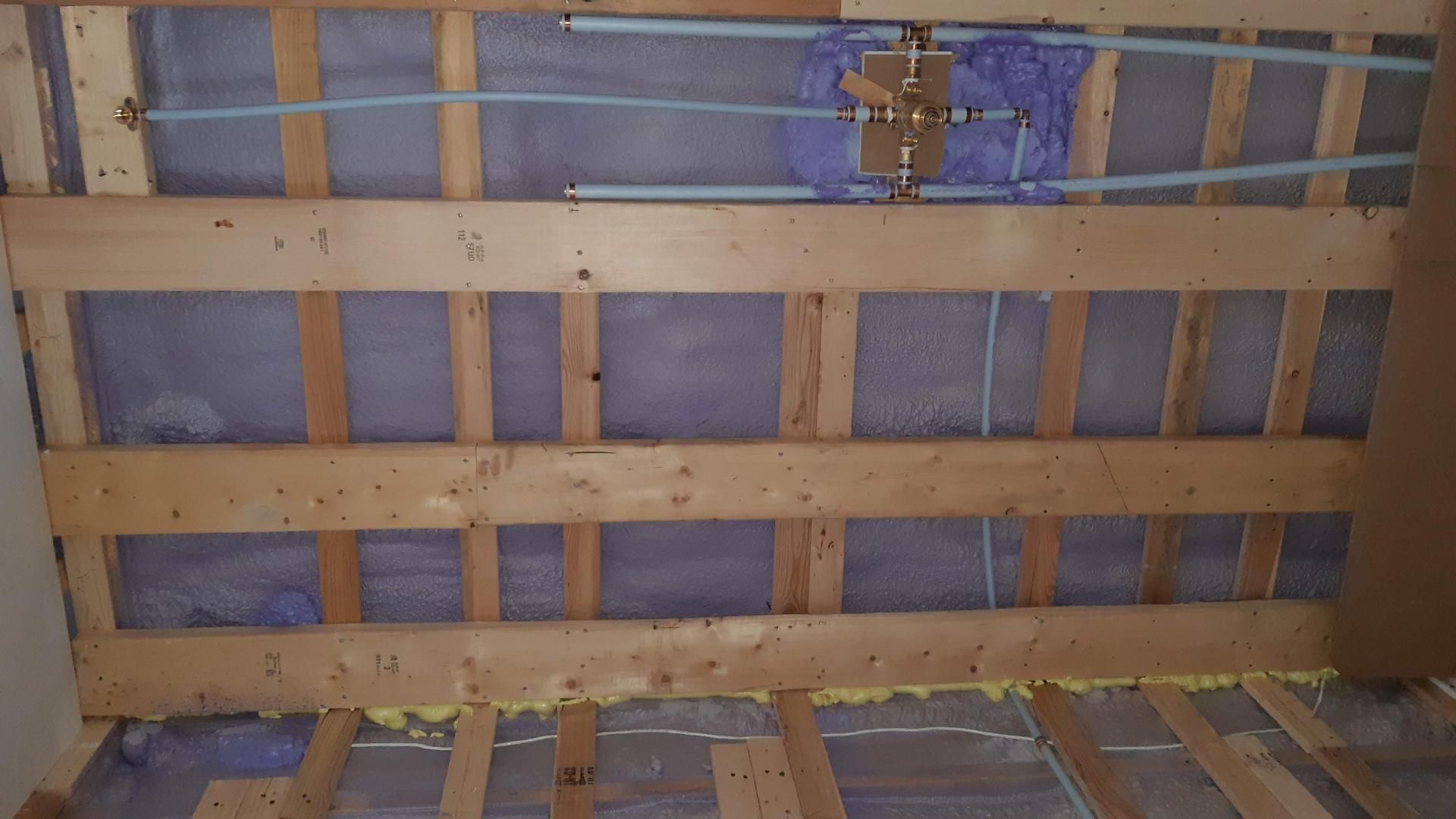 Charpente murale en bois avec plomberie, isolation et ensemble de vannes.