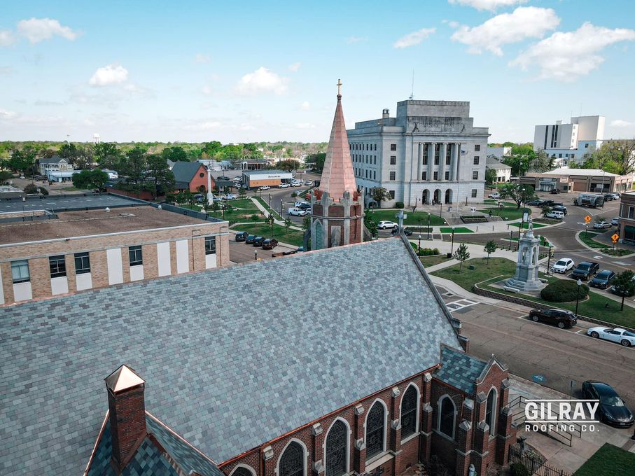 An aerial view of a church and a courthouse in a small town.