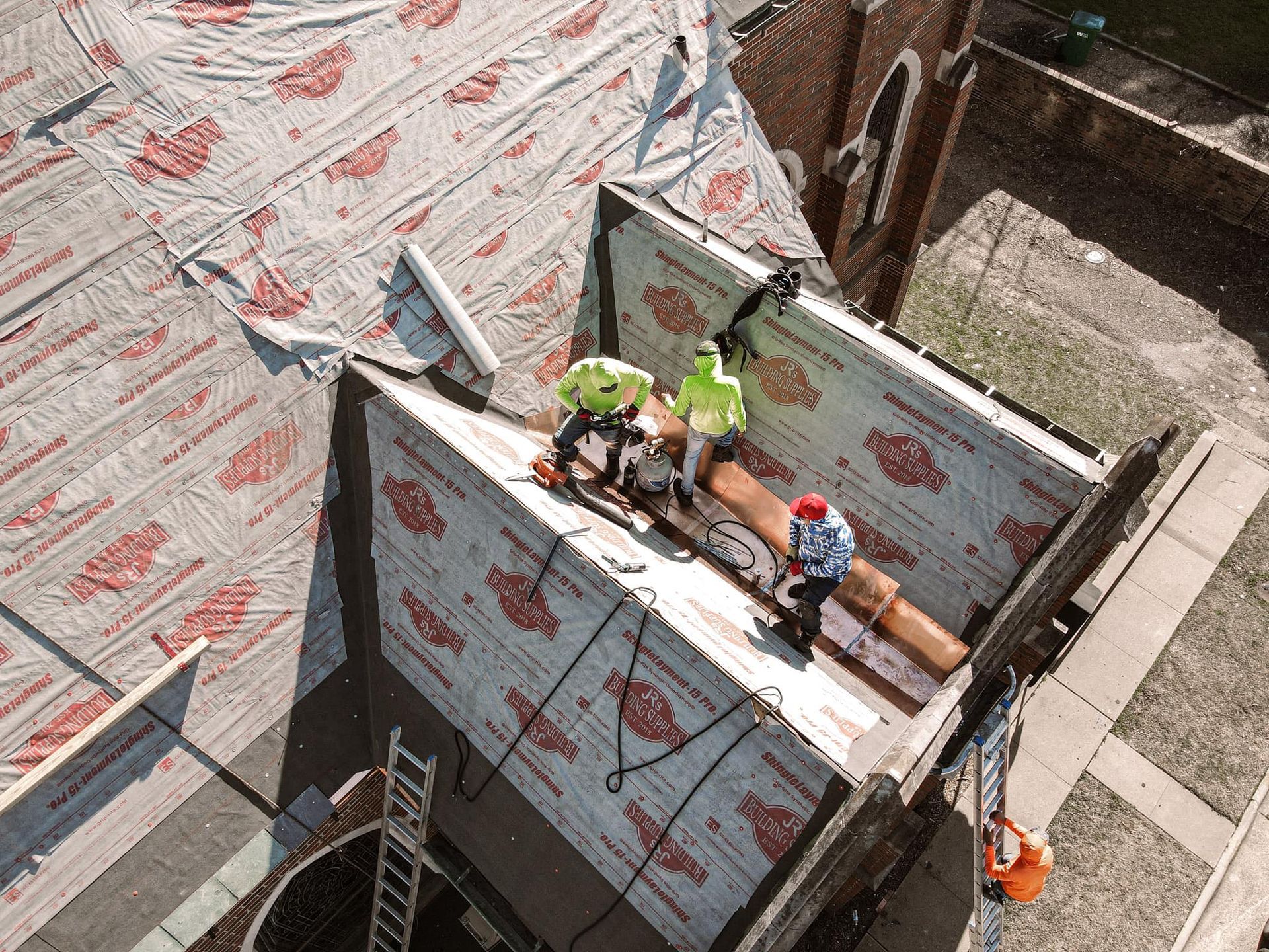 A group of construction workers are working on a roof.