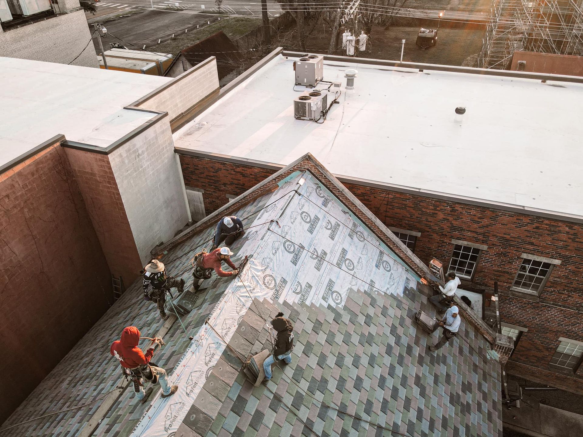 A group of people are working on the roof of a building.
