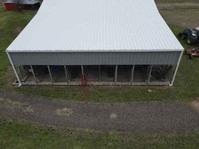 An aerial view of a barn with a white roof.
