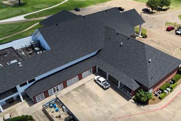 An aerial view of a large building with a black roof