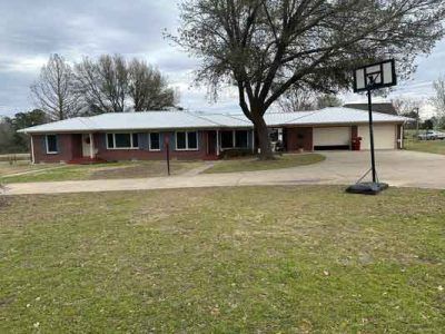 A large brick house with a basketball hoop in front of it.