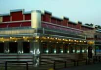A diner with a lot of windows and a red awning.