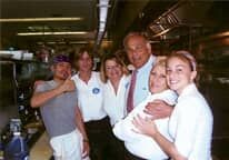 A group of people are posing for a picture in a kitchen.