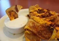 A close up of a plate of food with a dipping sauce.