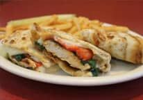 A white plate topped with a sandwich and french fries.