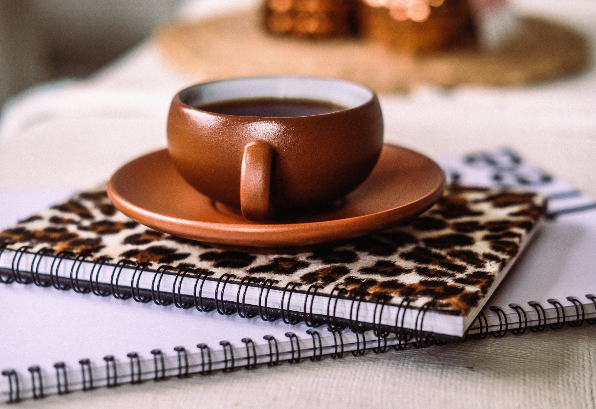Kaffeetasse auf Notizbuch mit Leopardenmuster