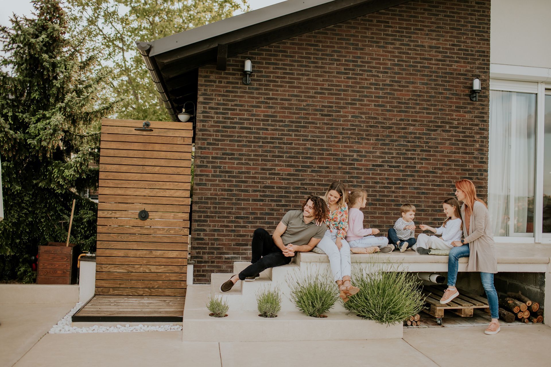 A family is sitting on the steps of a house.