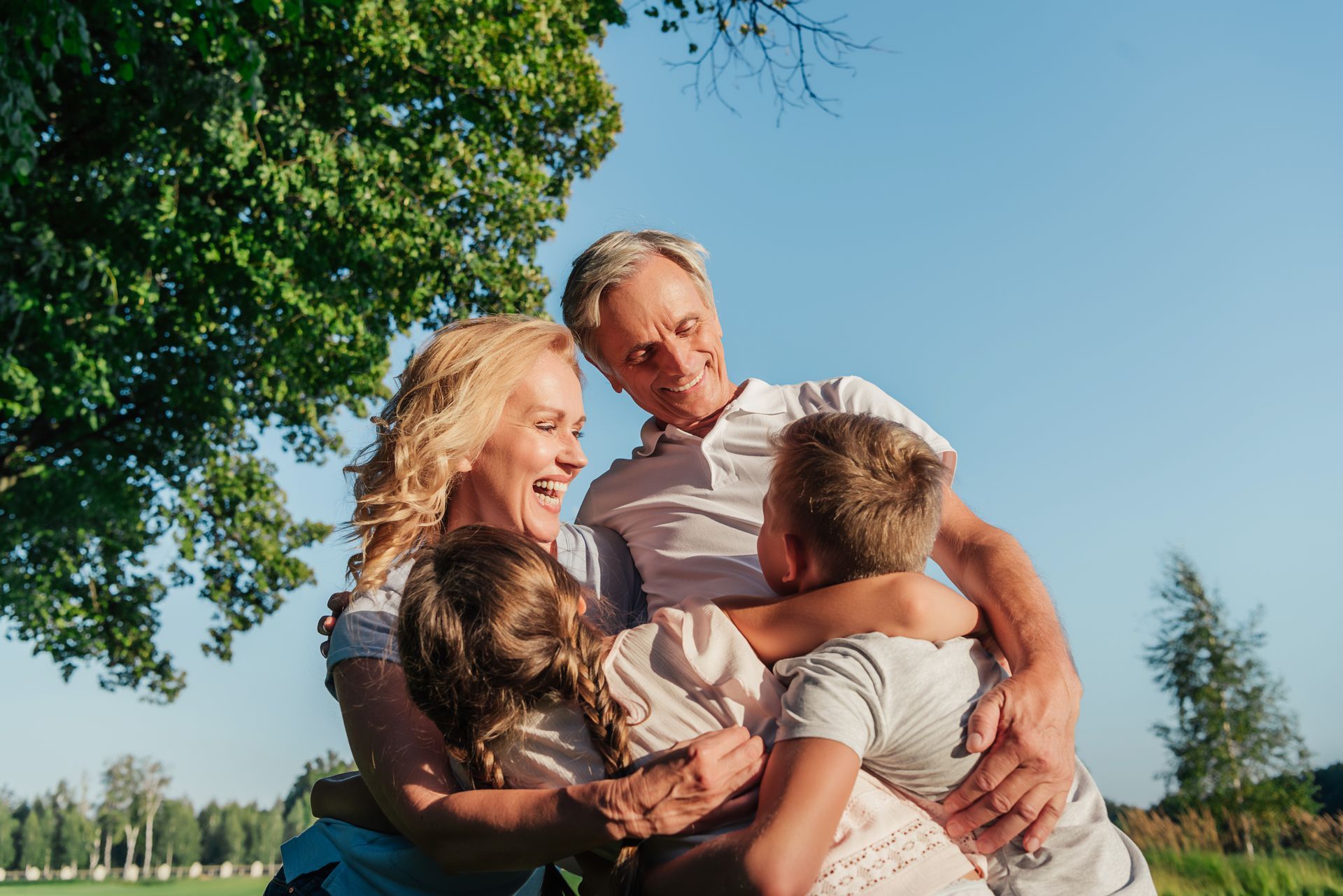 A family is hugging each other in a field.