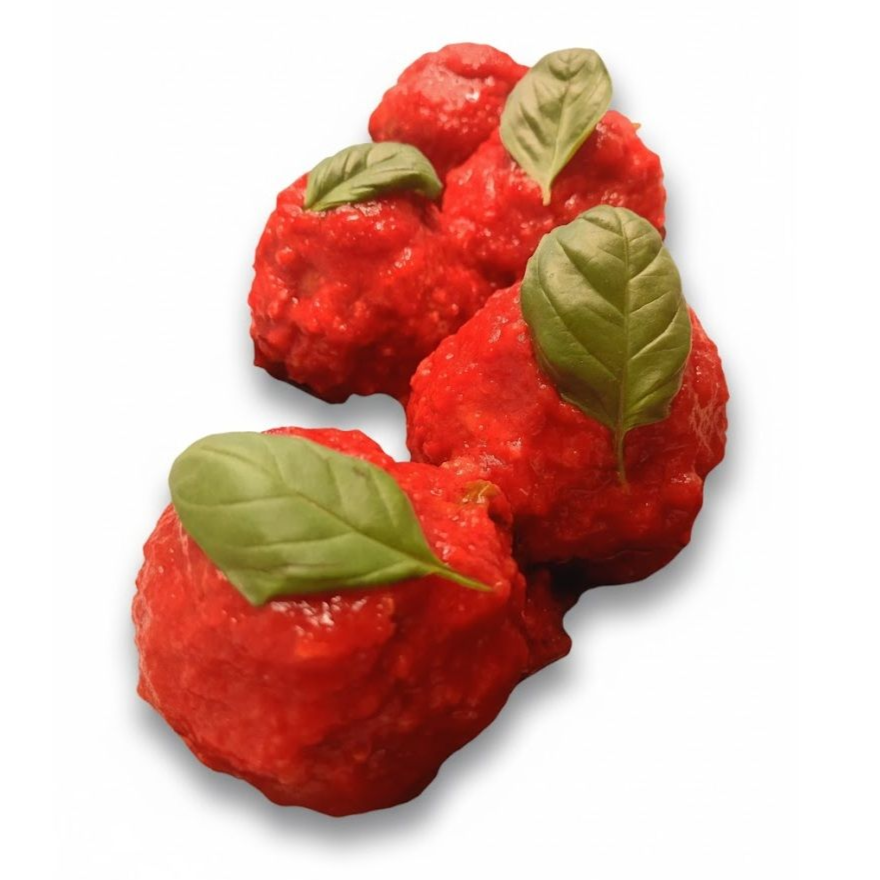 Polpette in salsa rossa, guarnite con foglie di basilico.