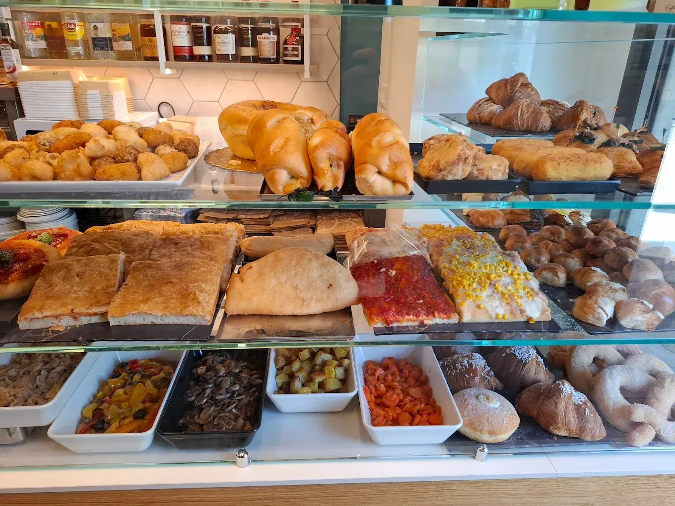 Vetrina da panetteria piena di dolci e prodotti salati.