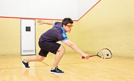 Man playing squash with glasses