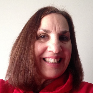 A woman wearing a red sweater is smiling for the camera