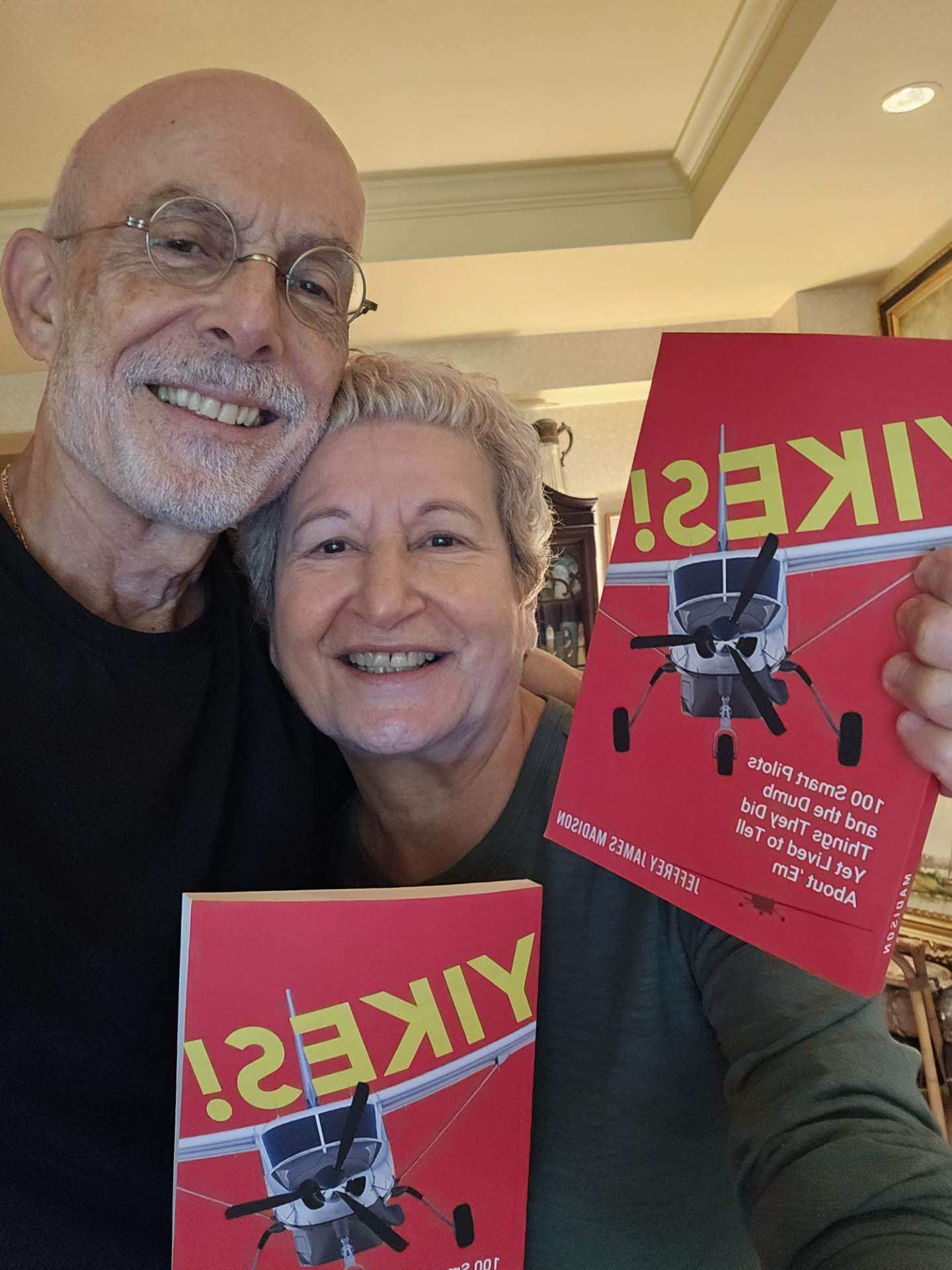 A man and a woman are posing for a picture while holding a book titled like ?