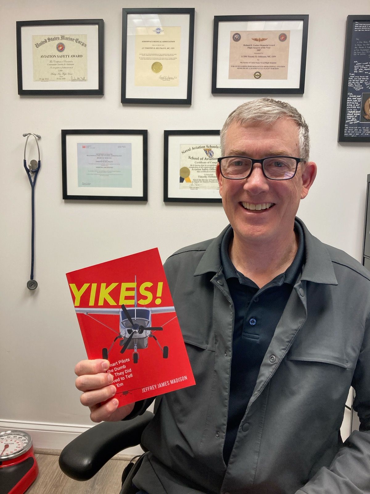 A man is holding a book that says yikes on it
