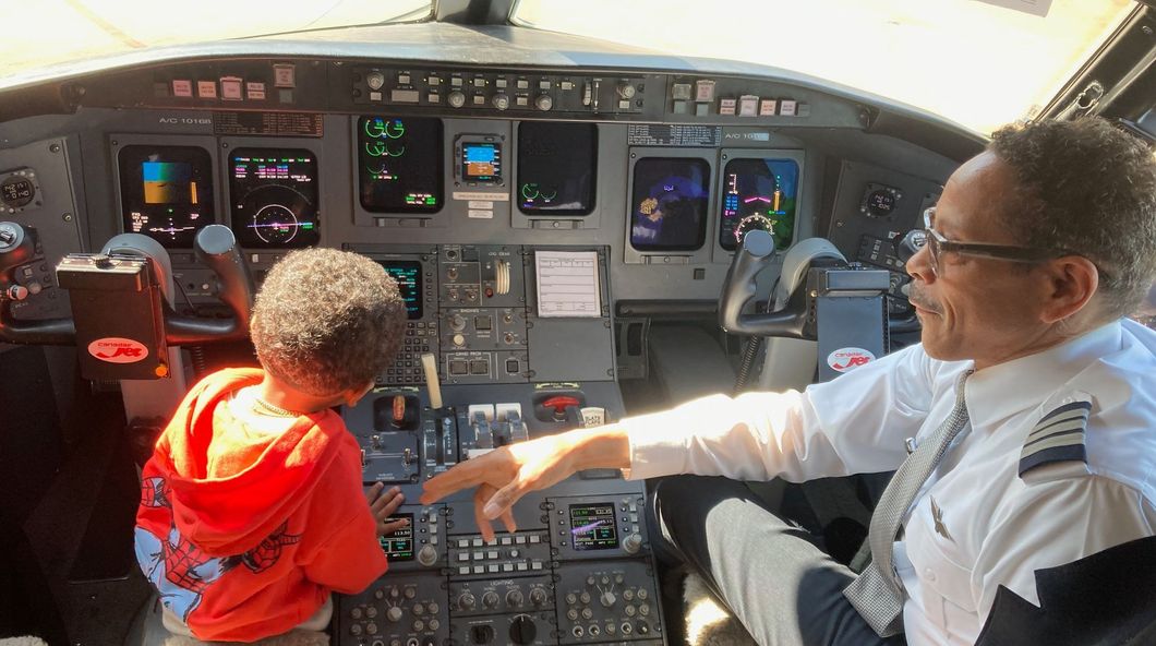 A pilot is teaching a young boy how to fly an airplane.