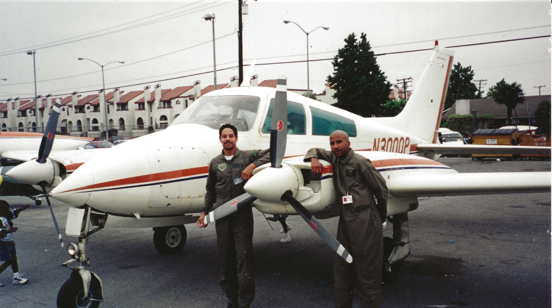 Three men are standing in front of a small plane with the numbers u3802 on the tail