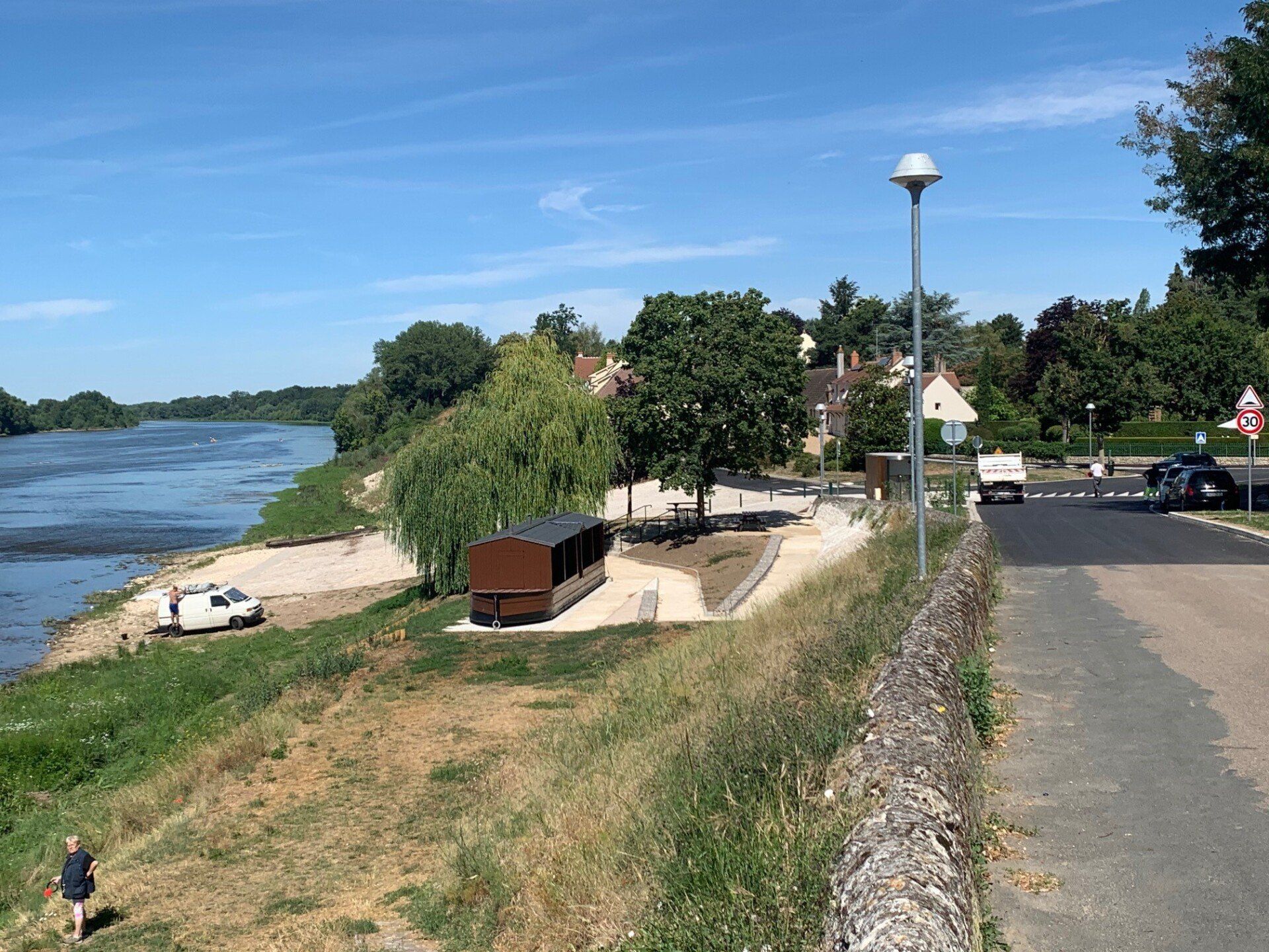 Un homme marche le long d'un sentier à côté d'une rivière.