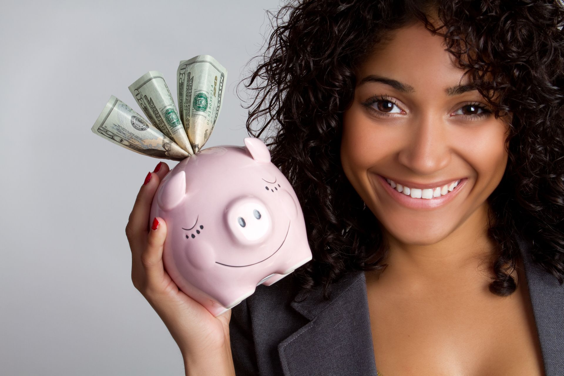 A woman is holding a piggy bank with money sticking out of it