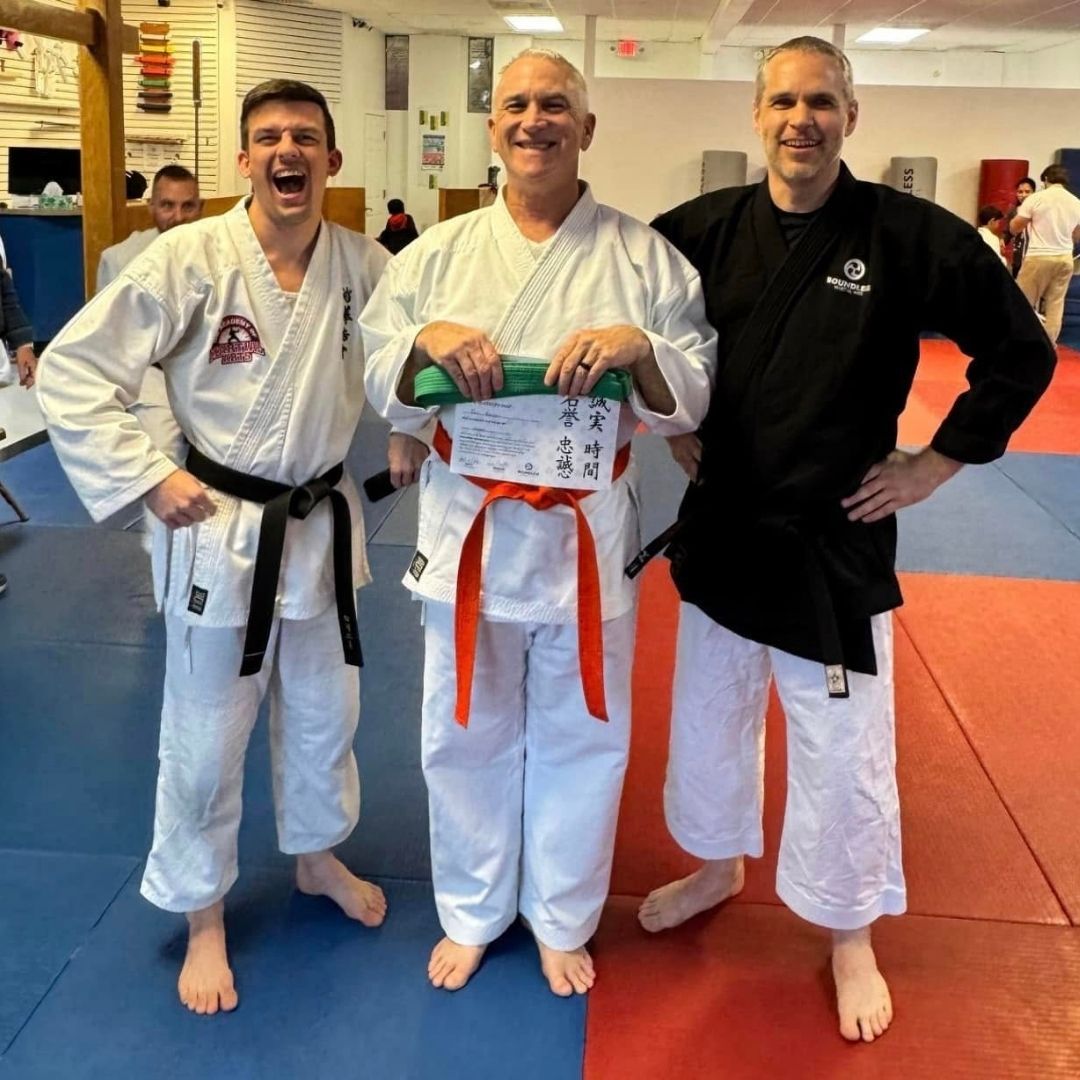 Two people practicing Brazilian Jiu-Jitsu on a mat. One is on top, applying a hold.
