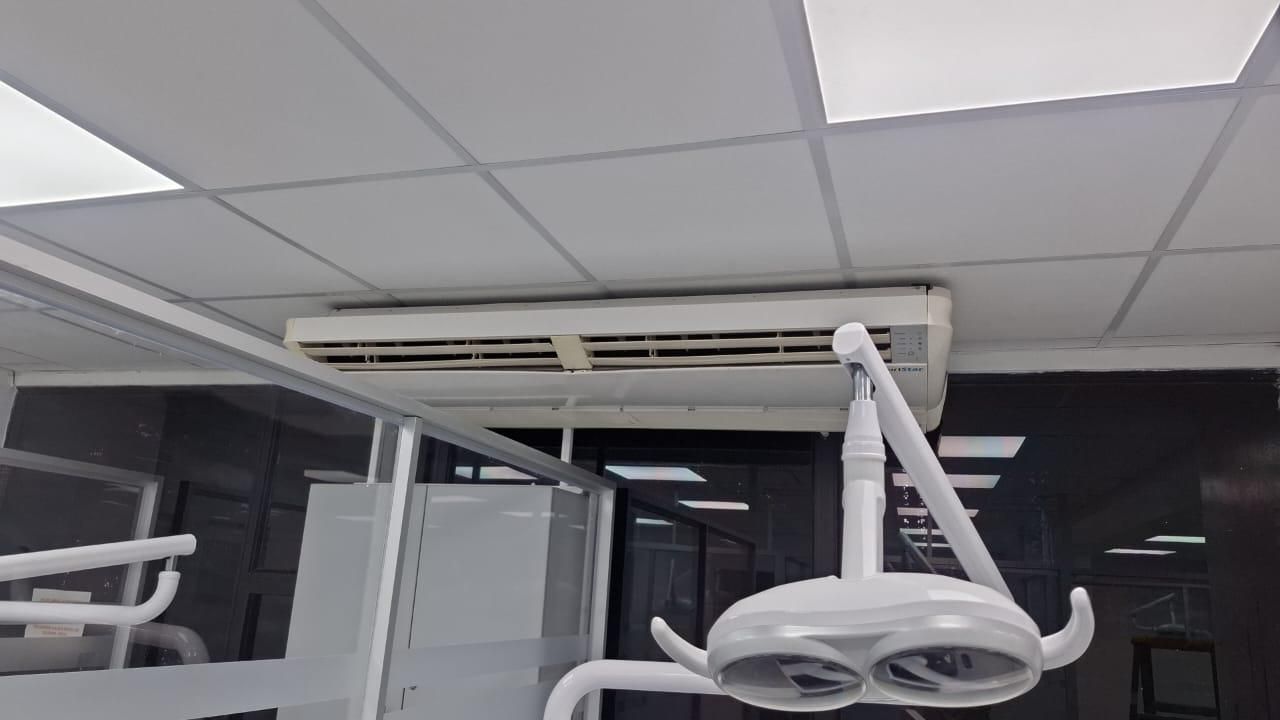 Lámparas quirúrgicas y equipos montados en el techo de una clínica dental en una sala de tratamiento.