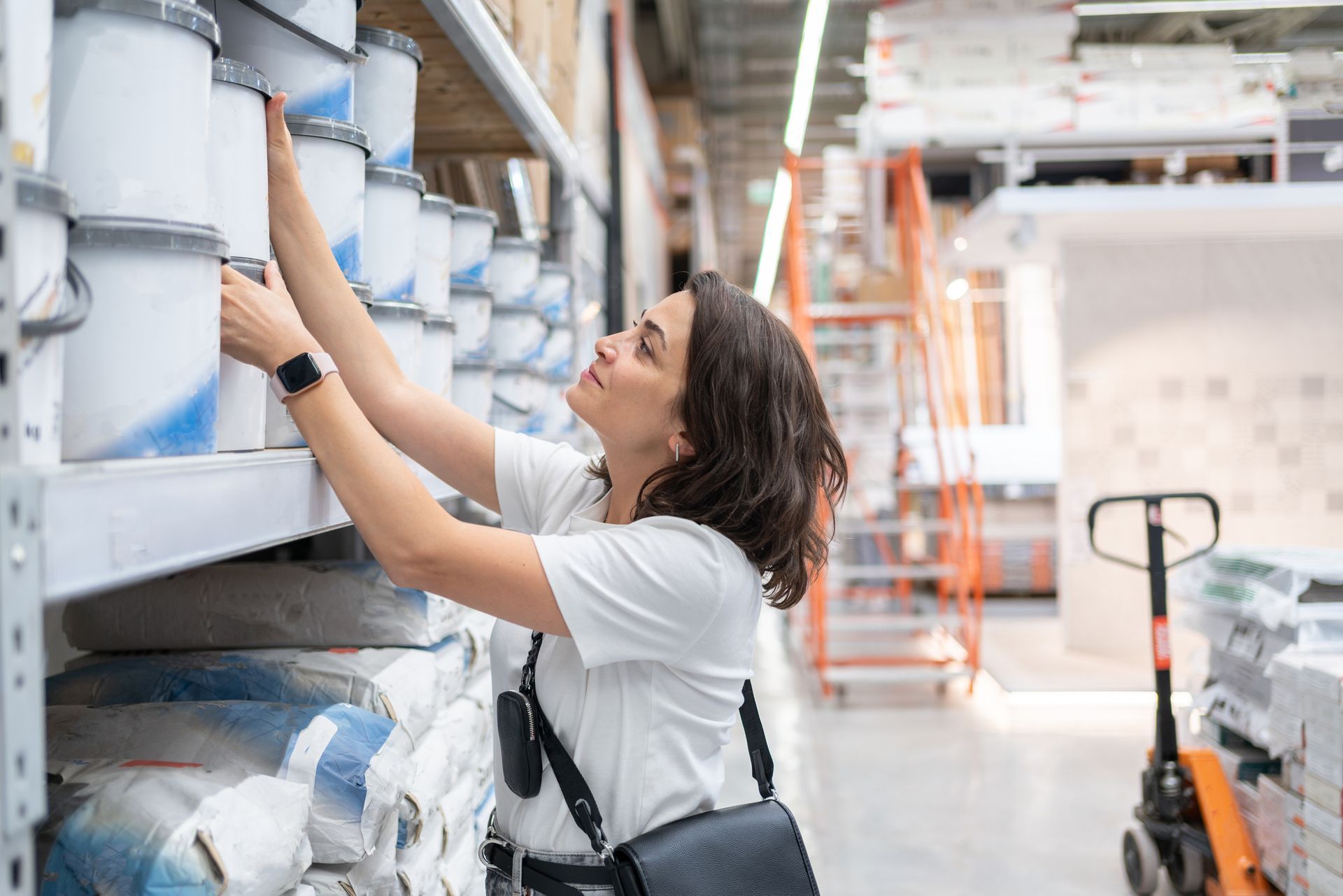 Woman selecting colorful paint samples in a store, exploring professional painting supplies.