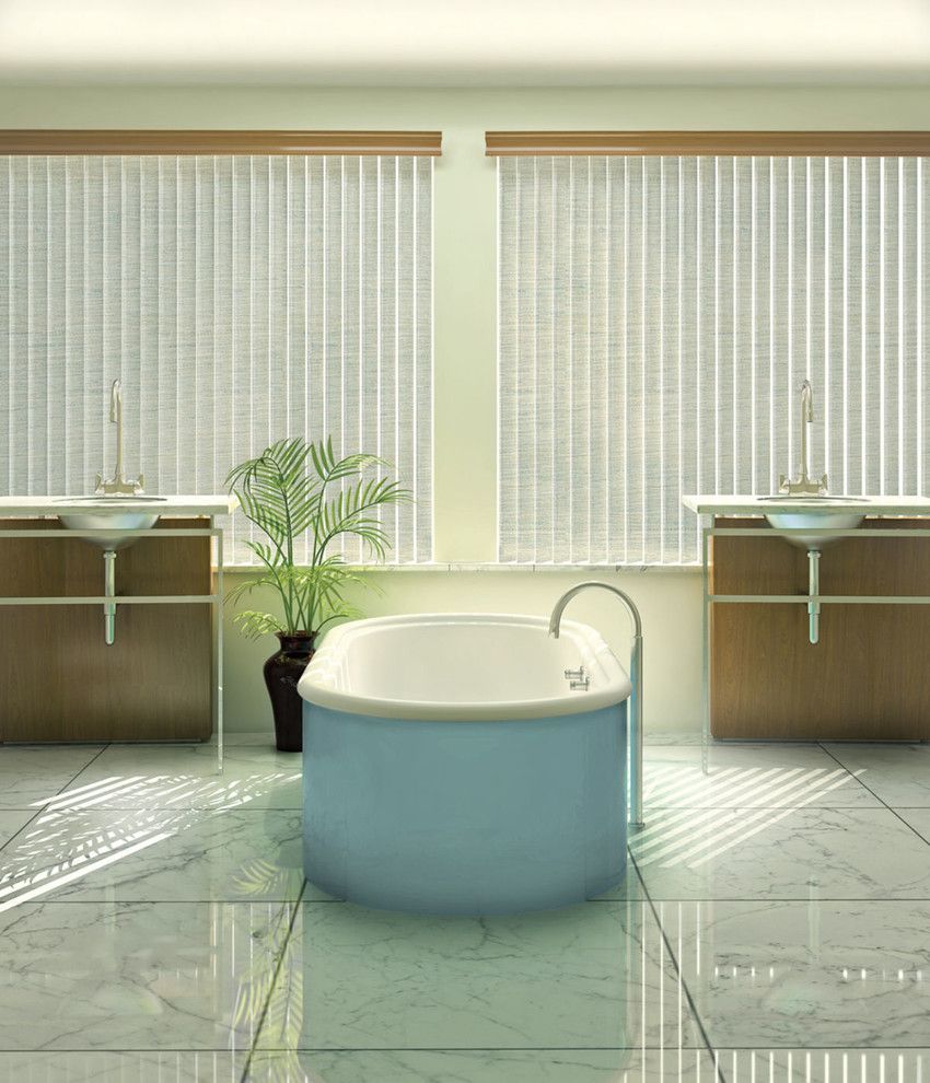 Bathroom with light blue tub, two sinks, window blinds, and sunlight.