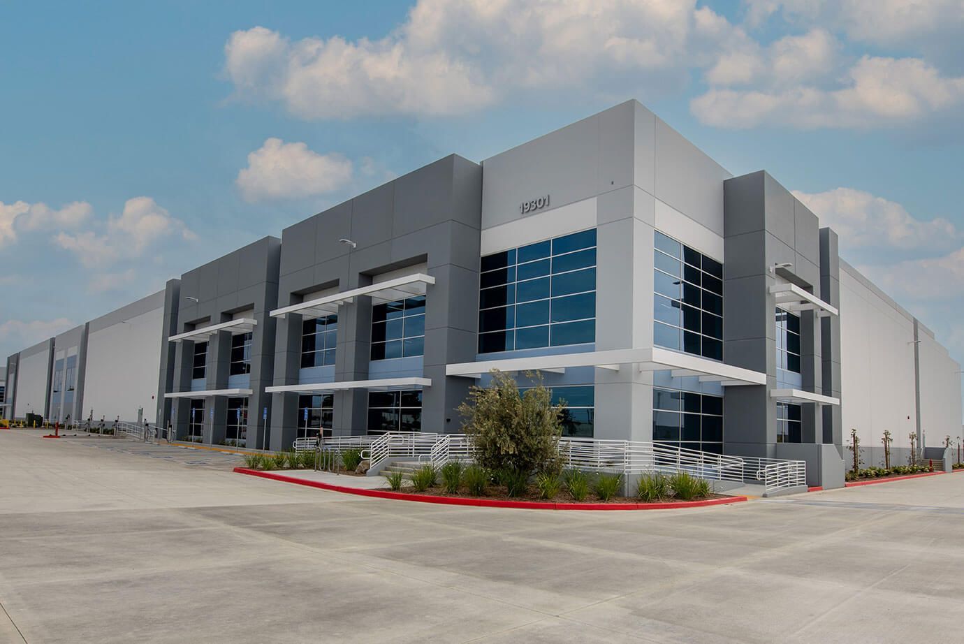 Exterior of a dental office with a gray and orange facade, blue sky, and a curved driveway.