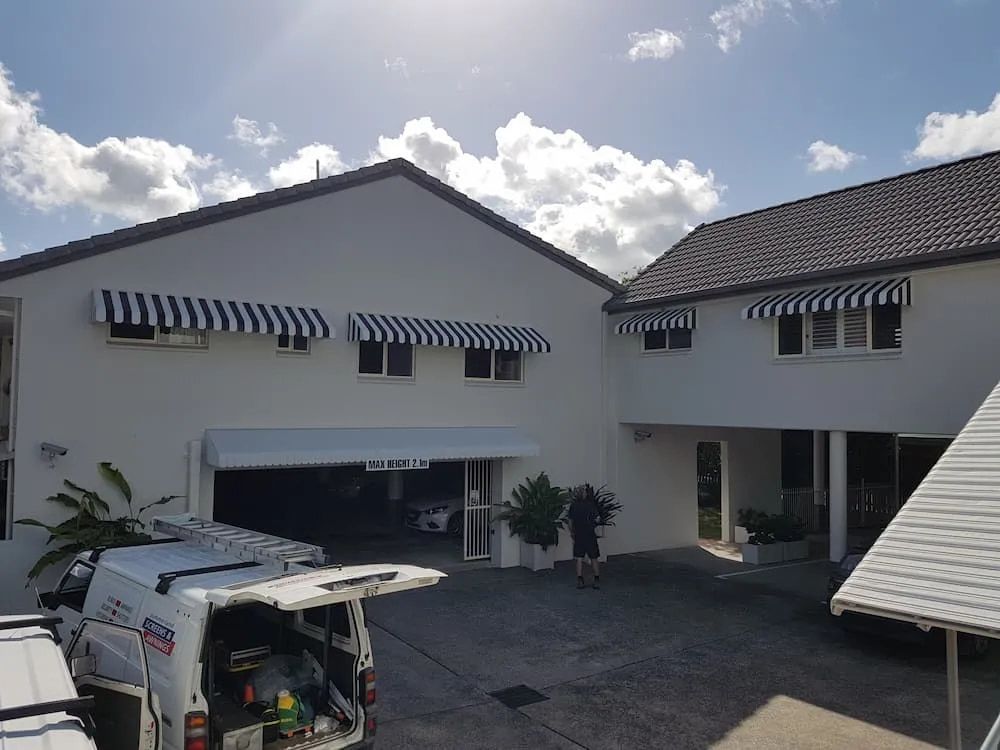 A House With Striped Awnings On The Windows — Summerland Screens & Awnings In Lennox Head, NSW