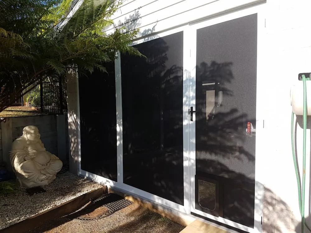 A White House With Black Screen Doors And A Statue In Front Of It — Summerland Screens & Awnings In Ballina, NSW