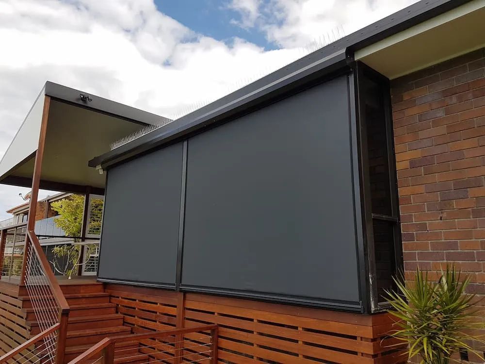 A Brick House With A Black Awning On The Side Of It — Summerland Screens & Awnings In Ballina, NSW