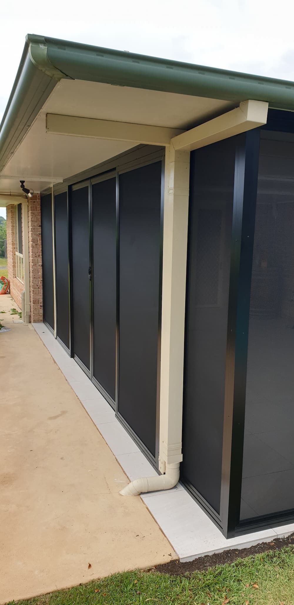 A House With A Row Of Black Shutters On The Side Of It — Summerland Screens & Awnings In Ballina, NSW