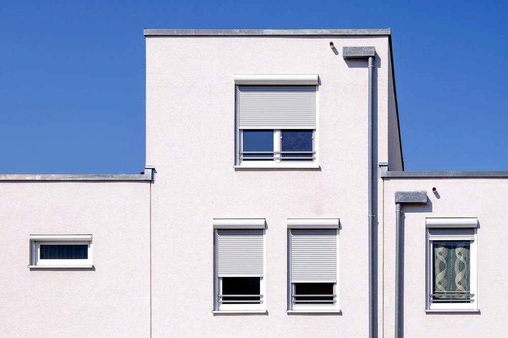 A White Building With A Blue Sky In The Background — Summerland Screens & Awnings In Suffolk Park, NSW
